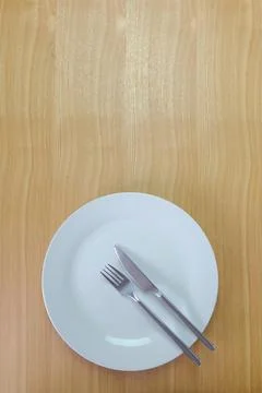Knife, Fork and dinner plate on table viewed from above Stock Photos