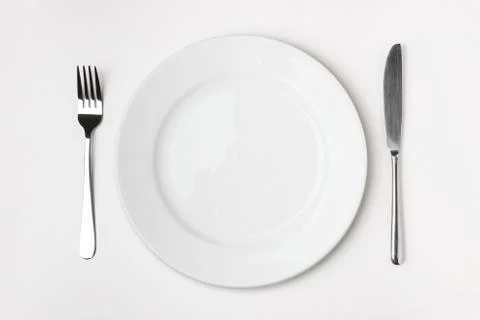 Knife, fork and plate on table. Stock Photos