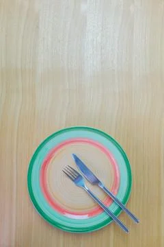 Knife, fork and plate on a table viewed from above Stock Photos