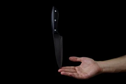 Knife on the hand on a dark background. Stock Photos