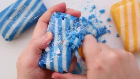 With a knife, he cuts striped colored soap into square, small pieces. Asmr. Vídeos de archivo 265771892