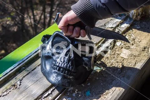A knife in his hand and an iron mask at the maniac Stock Photos