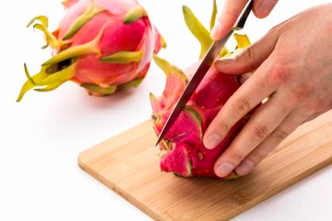 Knife in position for a first cut through a pitaya Stock Photos