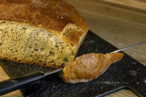 A knife with a sharp blade for cutting bread, slicing a loaf of white fresh.. Stock Photos