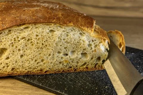 A knife with a sharp blade for cutting bread, slicing a loaf of white fresh.. Stock Photos