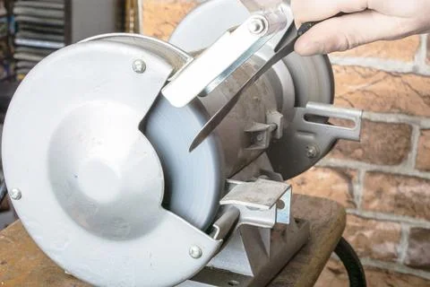 Knife sharpener and hand with blade on table, closeup Stock-Fotos