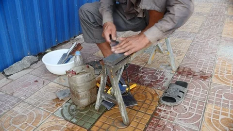 Knife sharpener whetting a cleaver on the sidewalk Stock-Footage 85648551
