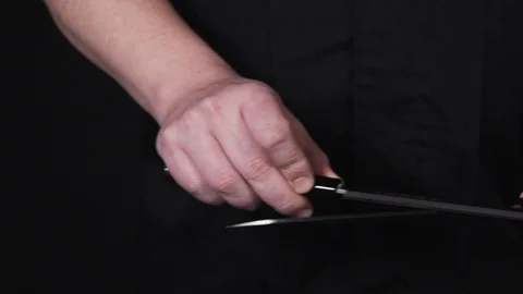 Knife sharpening by an expert chef on the black background. Stock Footage 113031032