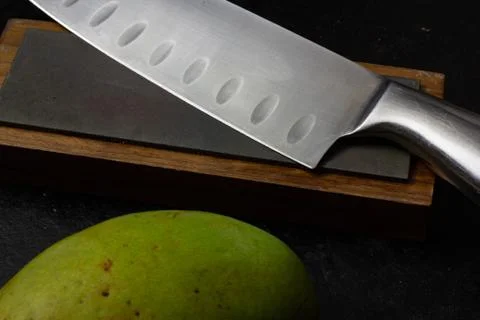 Knife on sharpening stone with mango Lao Stock Photos