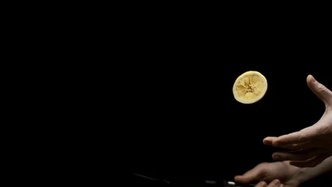 A knife slicing a falling lemon in half Stock Footage 128721025