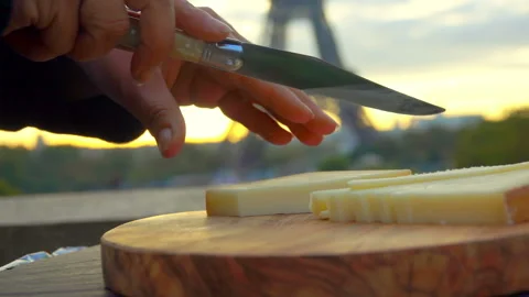 Knife slicing hard cheese on backdrop Eiffel Tower Stock Footage 122996122