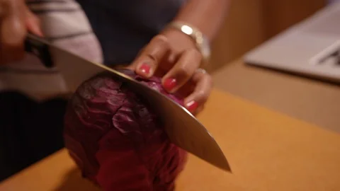 Knife slicing head of red cabbage in half then chunks Stock Footage 124225608