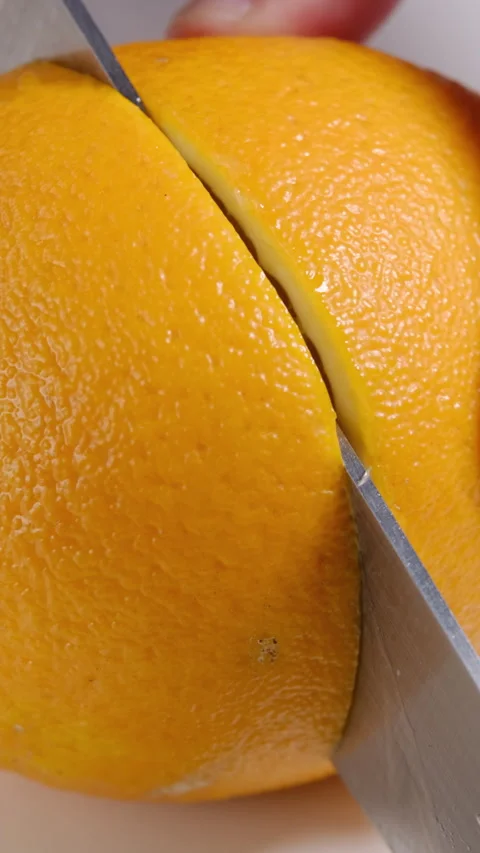 Knife slicing an orange close up Stock Footage 302506911