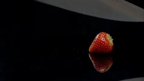 A knife slicing a strawberry in half Stock Footage 128695320