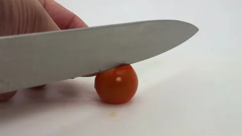 Knife Slicing Through An Isolated Cherry Tomato, London, UK 動画素材 133195039