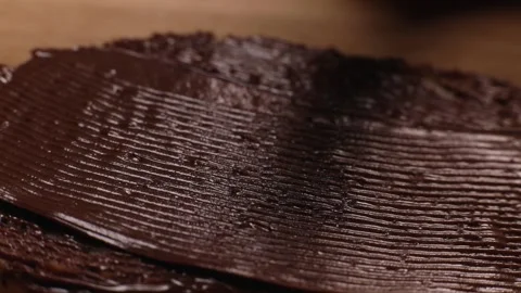 Knife smears chocolate paste, butter close-up, macro on bread toast Stock Footage 230180691