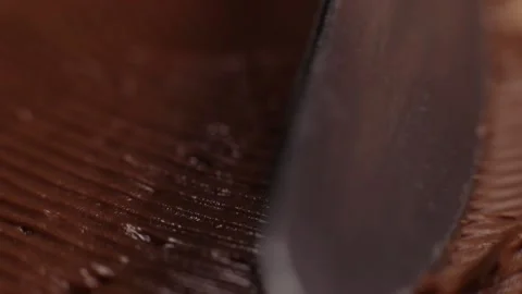 Knife smears chocolate paste, butter close-up, macro on bread toast Stock Footage 230180744