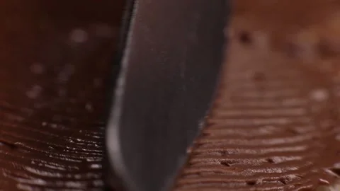 Knife smears chocolate paste, butter close-up, macro on bread toast Stock Footage 230180763