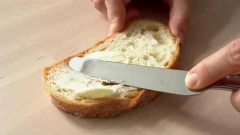 Knife spread white butter on slice of bread. Stock Footage 231795168