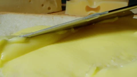 Knife spreading butter on a piece of bread, close up view. Breakfast or lunch Stock Footage 195306578