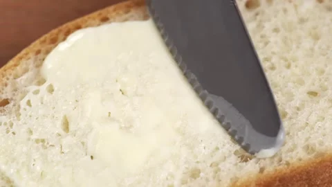 Knife spreading butter on a piece of bread, close up. Spreading cream chees.. Stock Footage 278470323