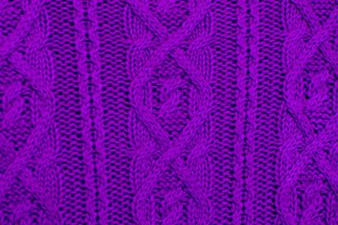 Knit texture of violet wool knitted fabric with cable pattern as background. Stock Photos