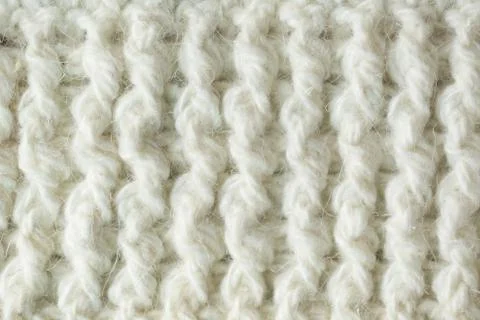Knit texture of white wool knitted fabric with cable pattern as background. Stock Photos