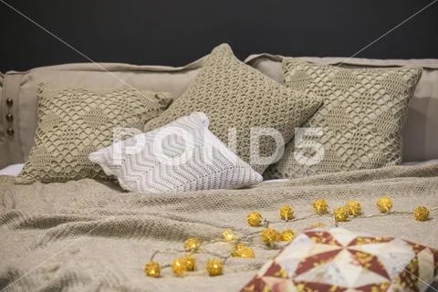 Knitted bed linens, knitted pillow cases, pillows, bedspreads, gray beige col Stock Photos