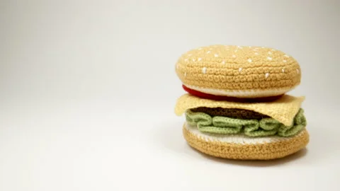 Knitted burger falls in a left side on a white background, Close Up Stock Footage 166548227