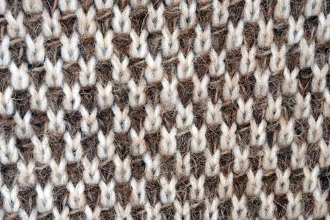 A knitted canvas of woolen threads. Brown and white threads knitting sweaters Stock Photos