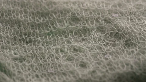 Knitted cloth with threads of white colour rotates closeup Video stock 121836501