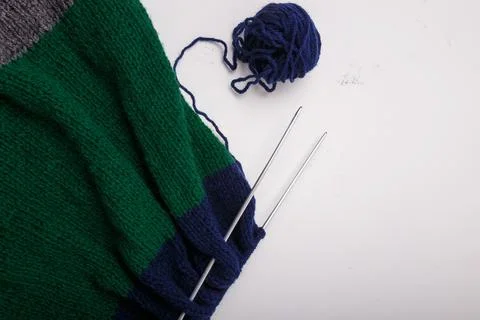 Knitted clothing, accessory in process of making. Knitting needles and ball Stock Photos