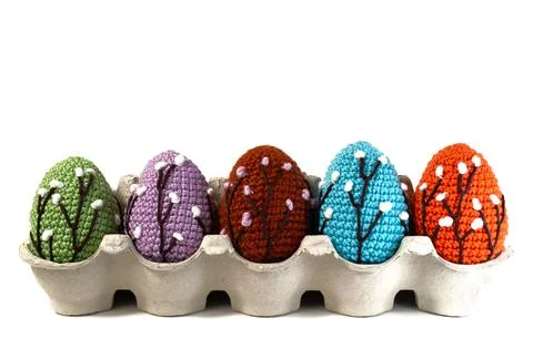 Knitted Easter eggs in paper lattice on white background with a branch of wil Stock Photos