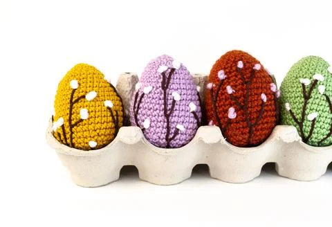 Knitted Easter eggs in paper lattice on white background with a branch of wil Stock Photos