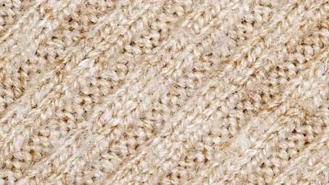 Knitted fabric made of beige threads, rotating Stock Footage 243987652