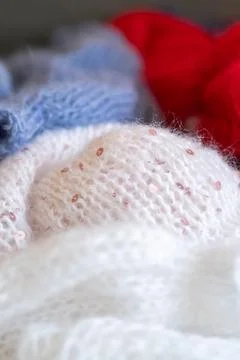 Knitted fabric with sequins soft texture, blue and red yarn, close up view. Stock-Fotos