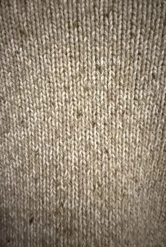 Knitted fabric texture background, close-up of beige interwoven textile pat.. Stock Photos