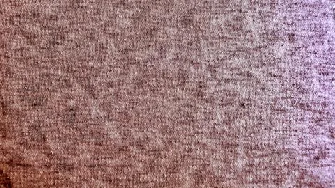 Knitted fabric texture macro closeup captures intricate details in warm earth 写真素材