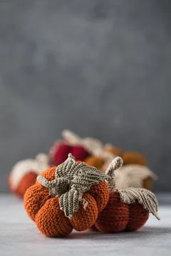 Knitted handmade pumpkins on a grey background. Autumn and coziness. DIY decor. Stock-Fotos