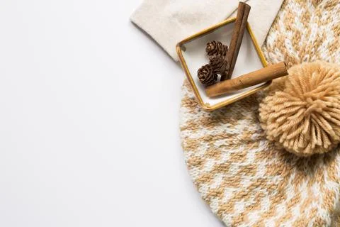 Knitted hat and Pine cones and cinnamon sticks in a bowl on white background 스톡 사진