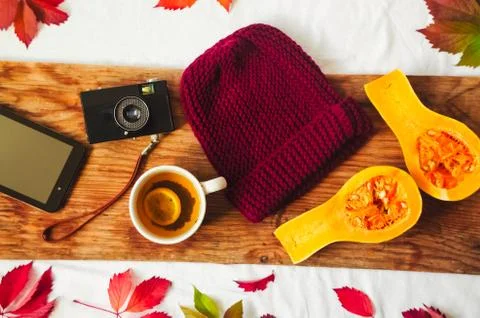 A knitted hat, a camera and a tablet. red leaves and hot tea Stock Photos