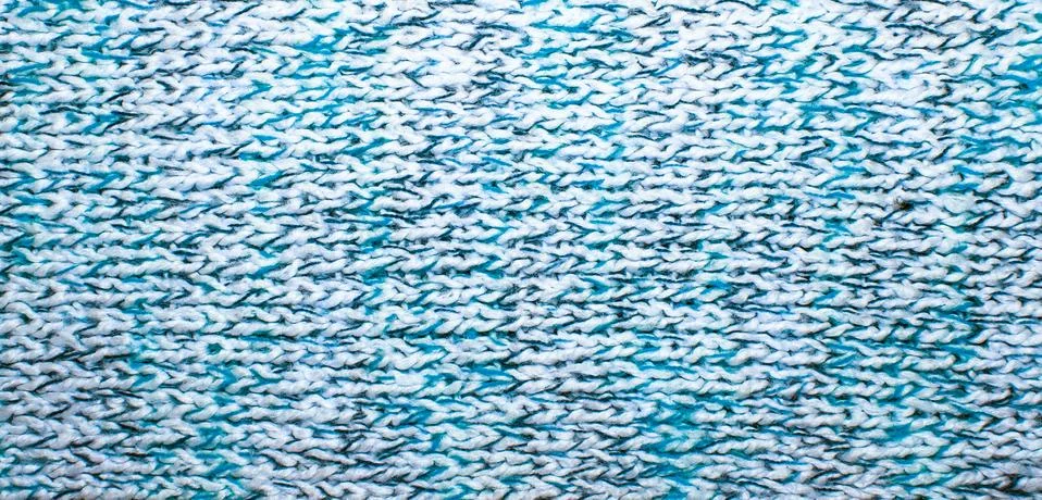 Knitted jersey background with a relief pattern Stock Photos