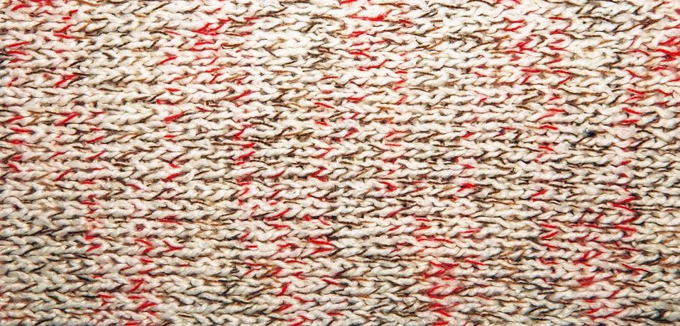 Knitted jersey background with a relief pattern Stock Photos
