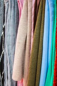 Knitted multi-colored plaids, blankets, knitted fabric textures in the store. Stock Photos