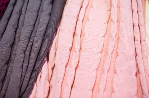 Knitted multi-colored plaids, blankets, knitted fabric textures in the store. Stock Photos