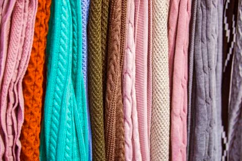 Knitted multi-colored plaids, blankets, knitted fabric textures in the store. Stock Photos
