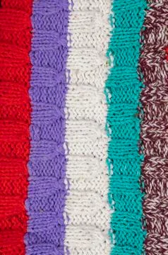 Knitted multi-colored texture. Background knitted stripes close-up. Фото