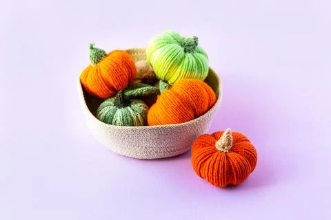 Knitted multicolored pumpkins in a basket Stock Photos