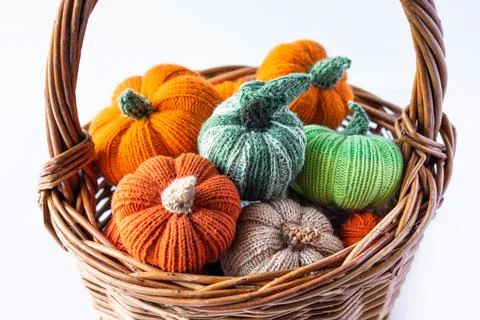Knitted multicolored pumpkins in a basket Stock Photos
