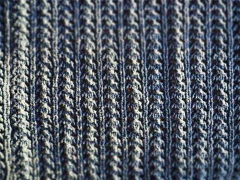 Knitted pattern of blue yarn. Lush machine or hand knitting. Warm wardrobe fo Stock Photos